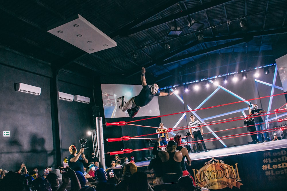 a person doing a stunt on a stage with a crowd watching