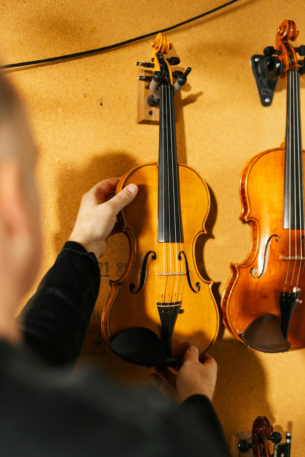 a man holding a violin in front of a wall
