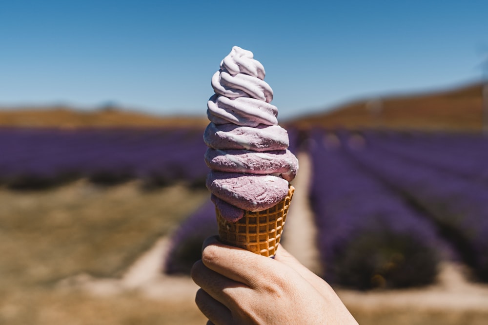 a hand holding an ice cream cone