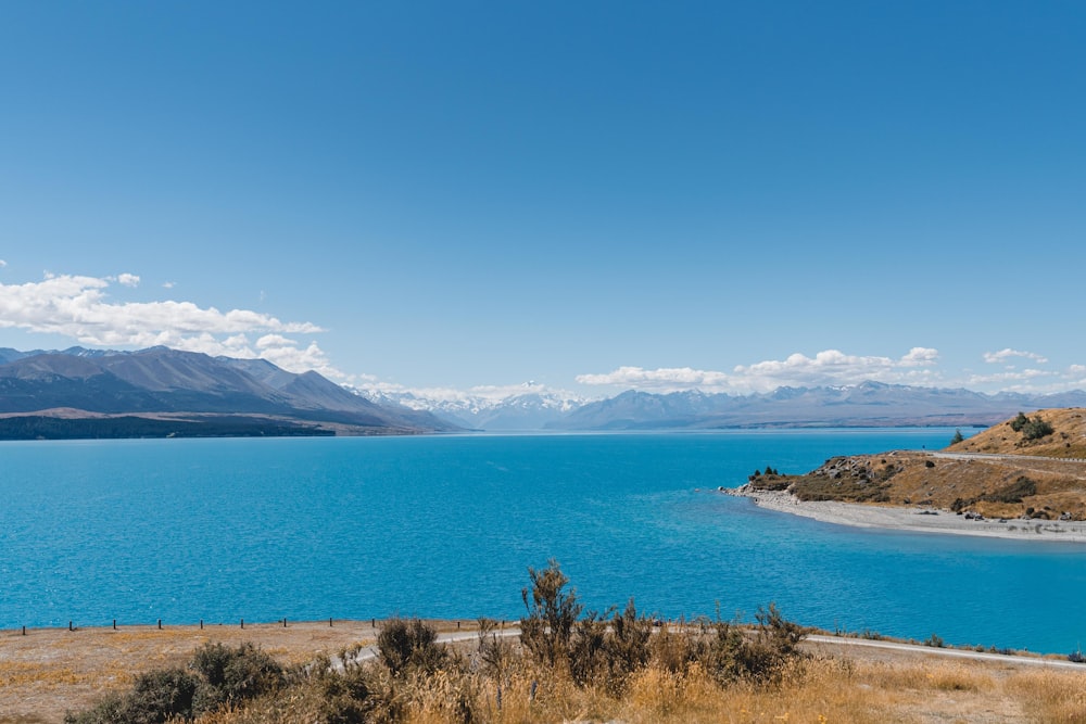 a body of water with mountains in the background