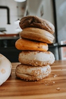 An assortment of colorful bagels arranged neatly on a wooden board.