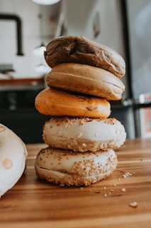 An assortment of colorful bagels arranged neatly on a wooden board.
