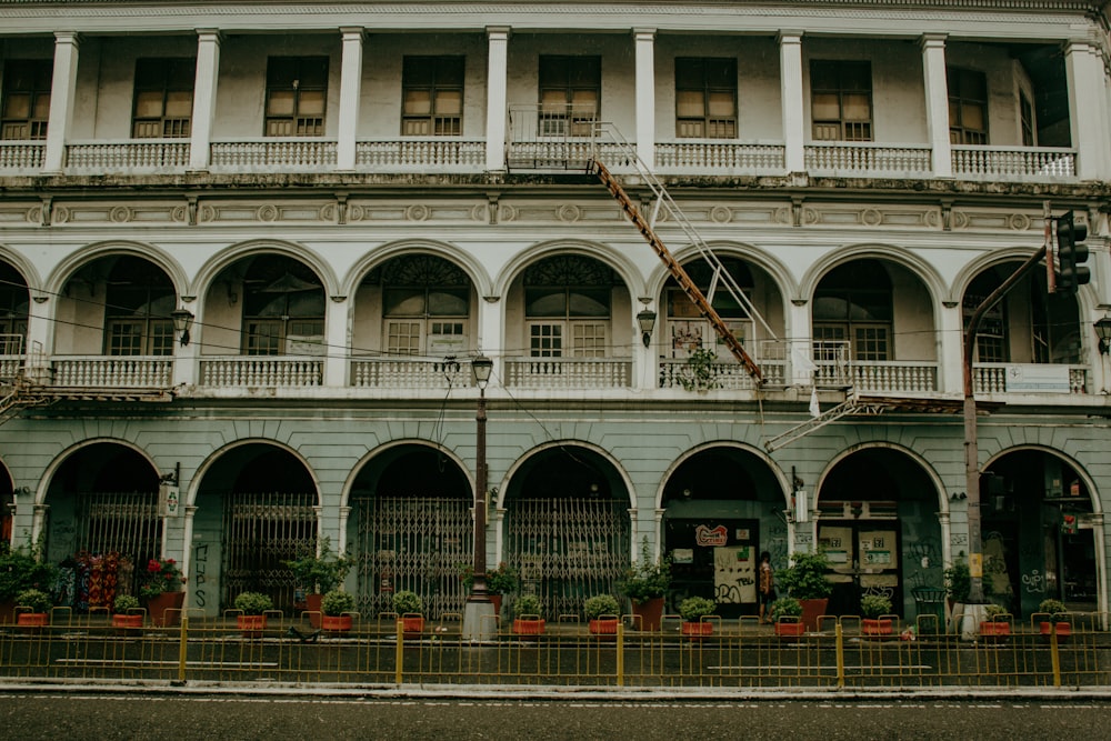 a building with many windows and plants in front of it