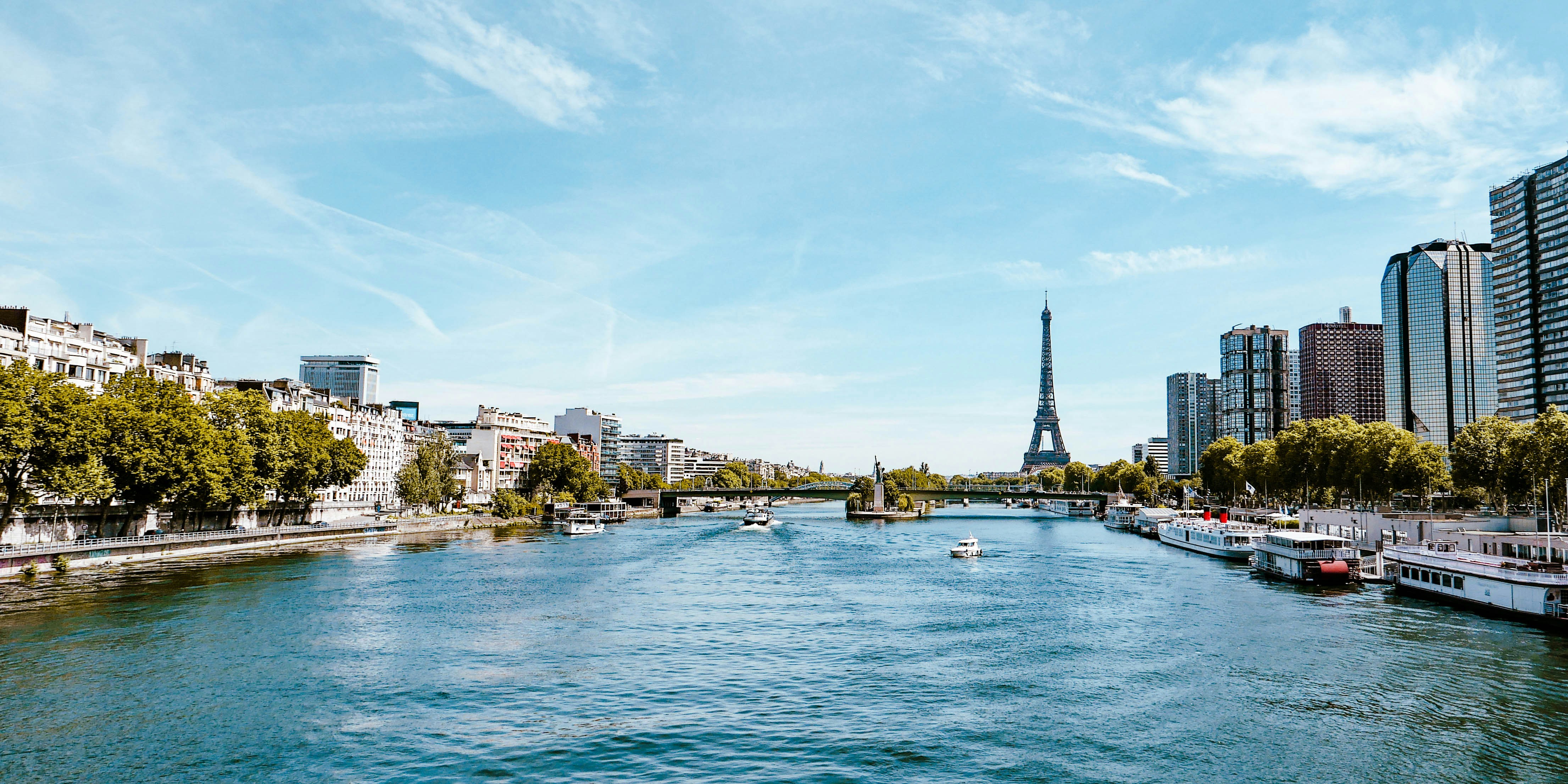 a body of water with boats and buildings in the background, Eiffel Tour and the Seine river