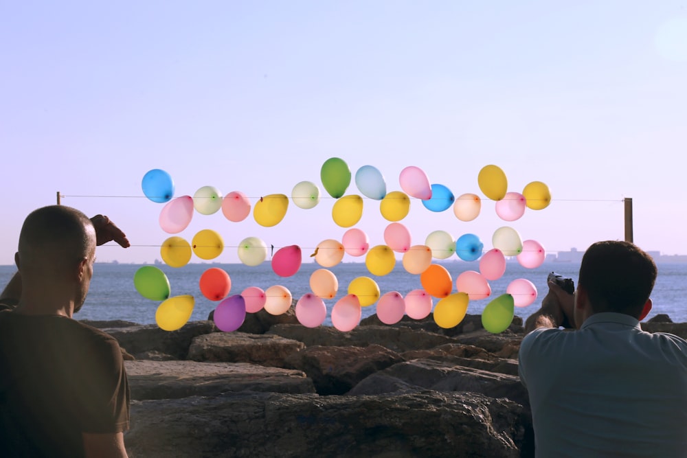 Eine Gruppe von Menschen, die auf eine Wand aus Luftballons schauen