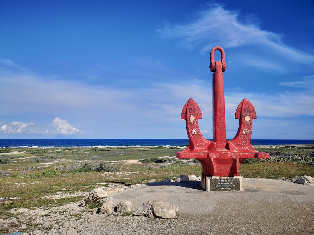 a red statue on a beach