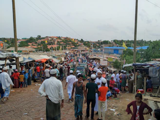 Field researcher conducting a survey with a diverse group of participants on a busy street in urban India.