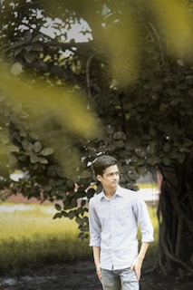 A friendly 4d tree service inc team member answering a phone call outdoors with lush trees in the background.