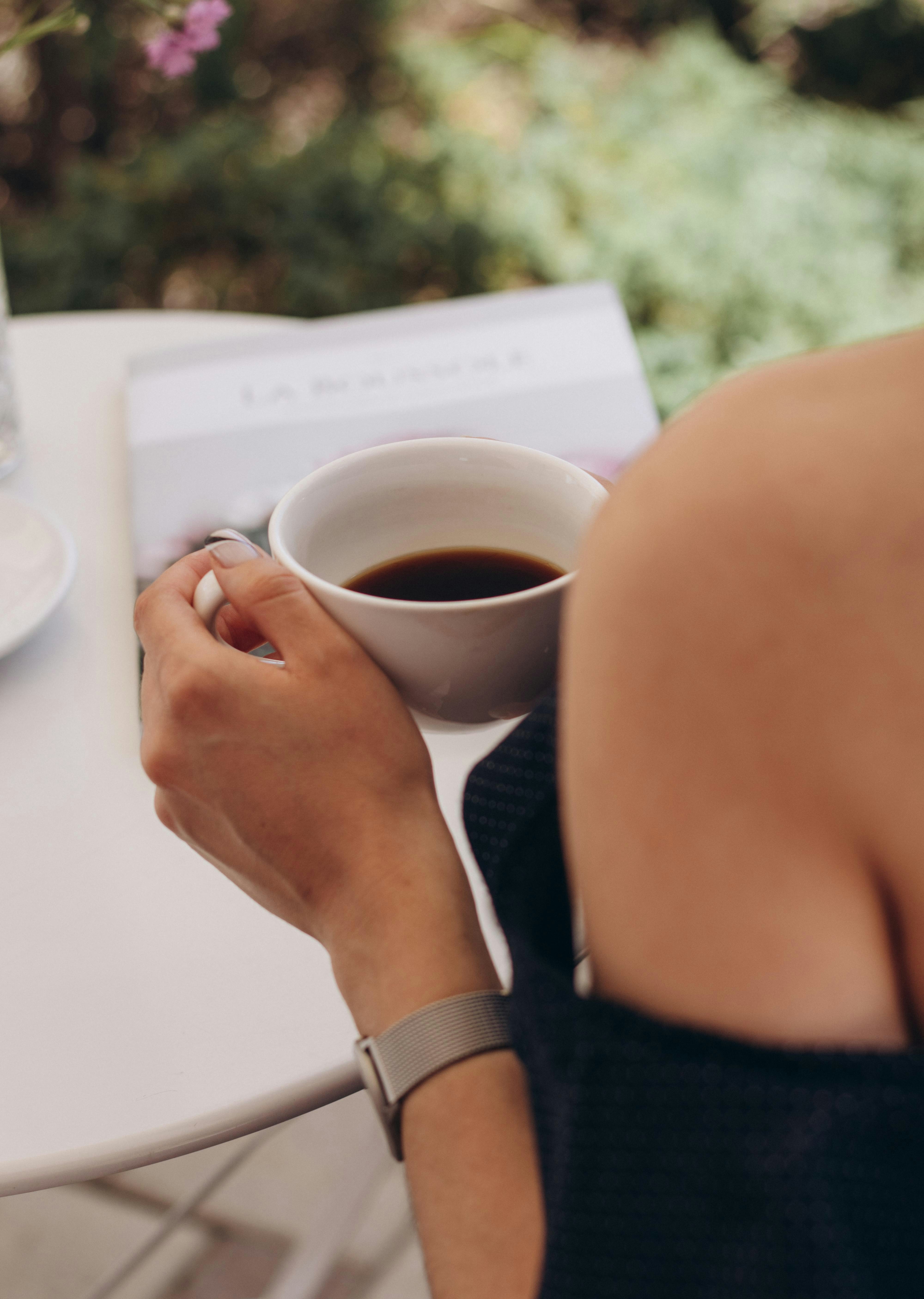 una persona che tiene in mano una tazza di caffè