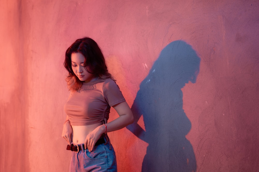 a person standing in front of a wall with a shadow of a person