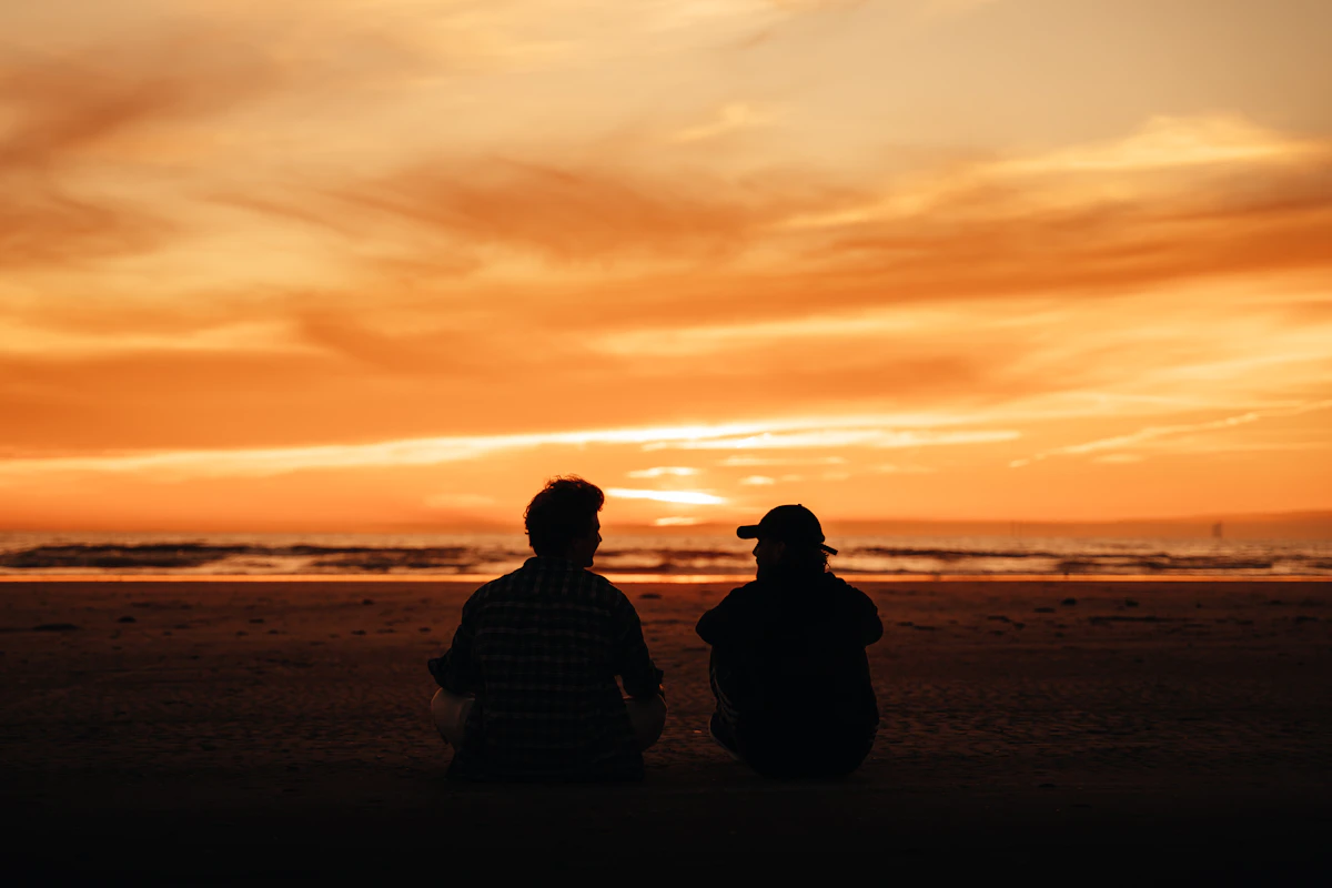 A couple together at the beach at sunset