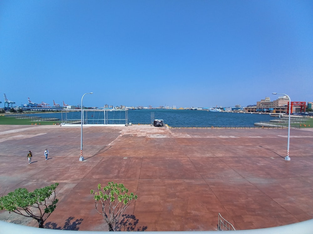 a brick walkway with a body of water in the background