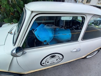 Classic white ride-on car with smooth curves and a comfortable seat