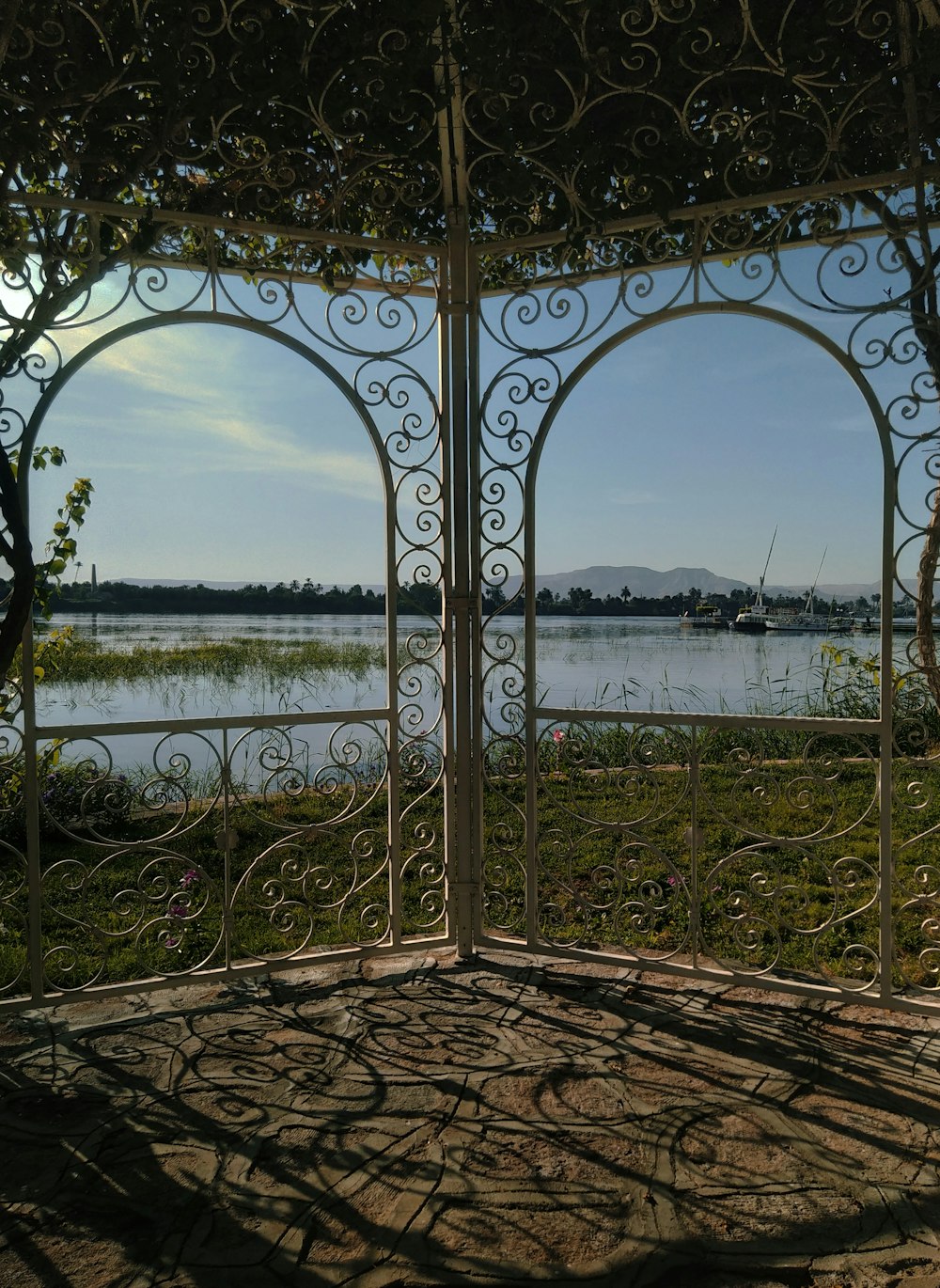a metal gate with a view of a lake and a city