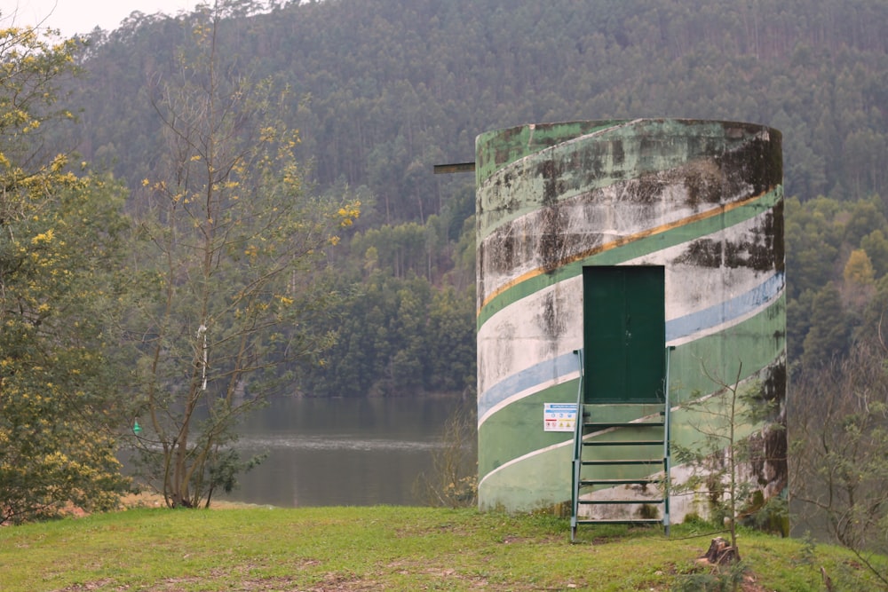 a green shed next to a lake