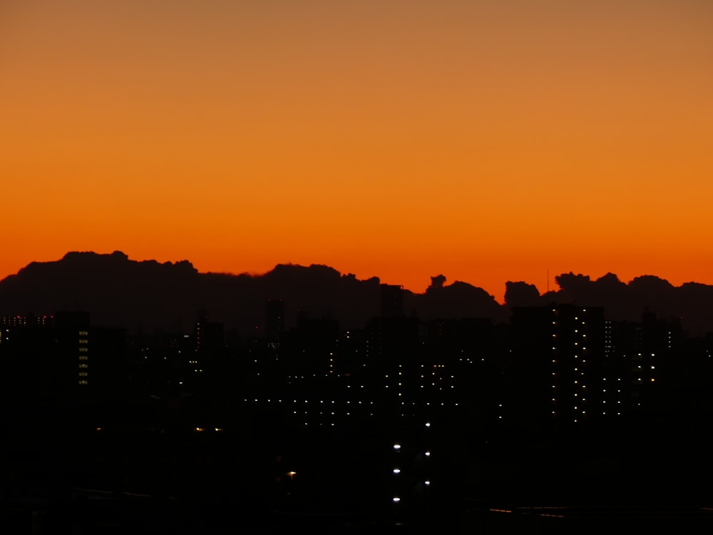 a sunset over a body of water with a city in the background