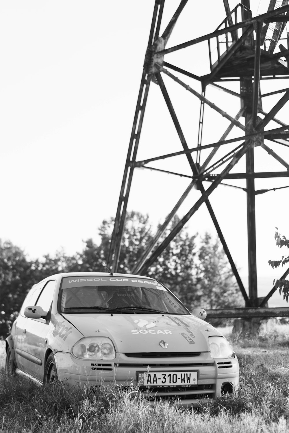 a car parked in front of a metal tower