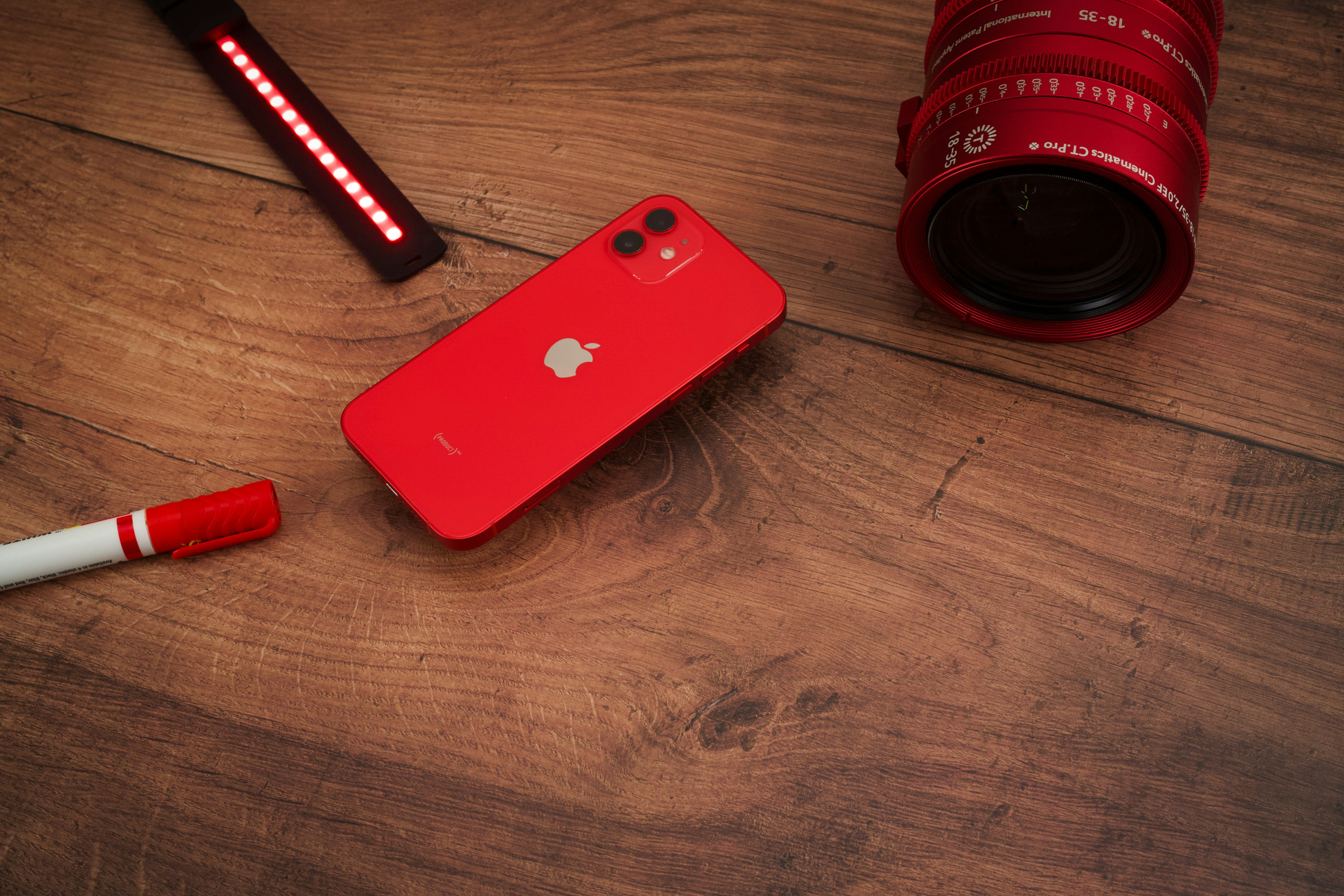 RED iPhone 12 on wooden table