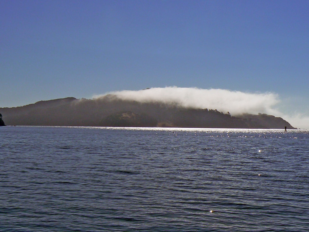 a body of water with a large wave in the distance