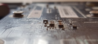 Close-up of a circuit board with capacitors and resistors glowing under soft light.