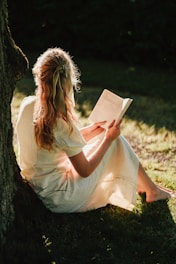 a person sitting on the ground reading a book