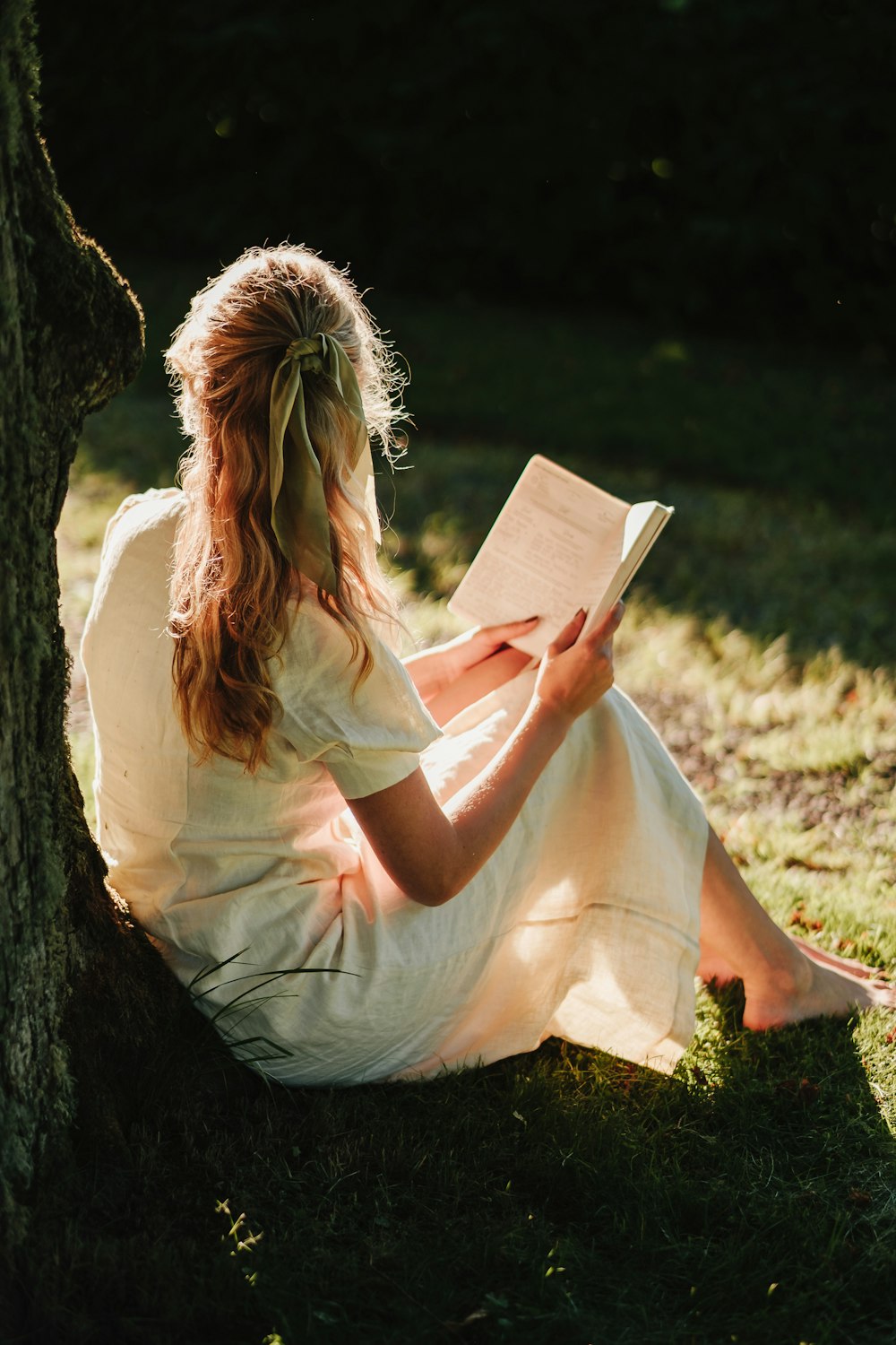 a person sitting on the ground reading a book