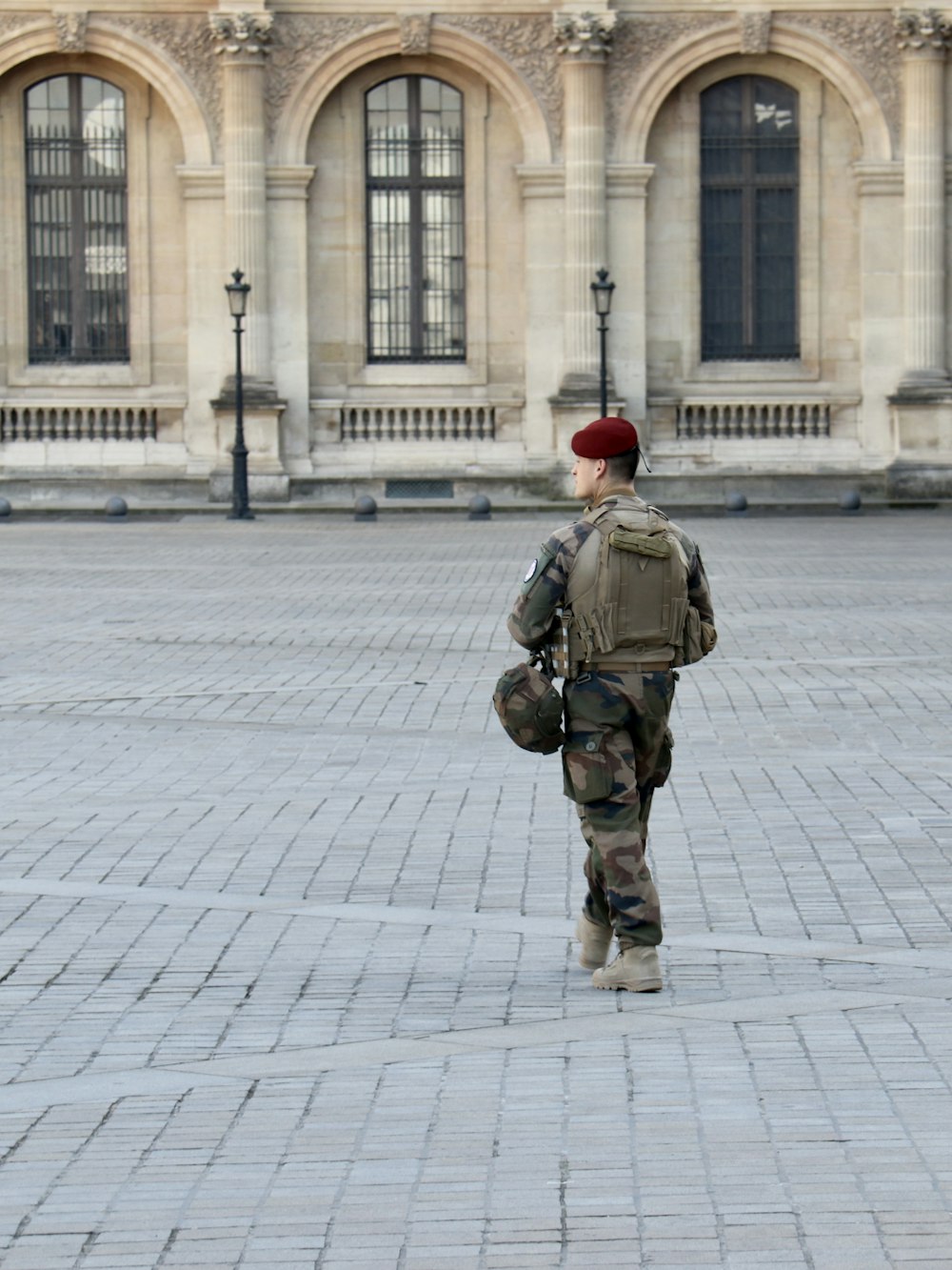 a person in military uniform walking in front of a building