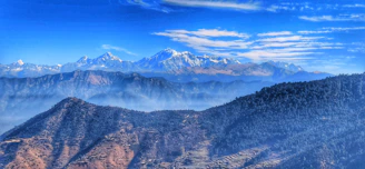 A panoramic view of the majestic Himalayas from the hills of Sikkim with a clear blue sky.