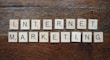 Wooden Scrabble tiles spell out the words 'INTERNET MARKETING' on a textured wooden surface.
