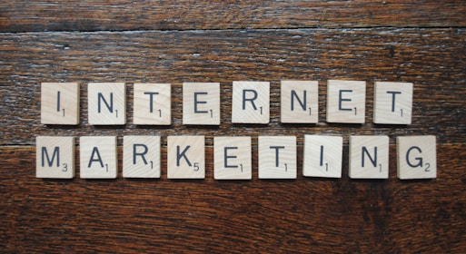 Wooden Scrabble tiles spell out the words 'INTERNET MARKETING' on a textured wooden surface.