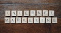 Wooden Scrabble tiles spell out the words 'INTERNET MARKETING' on a textured wooden surface.