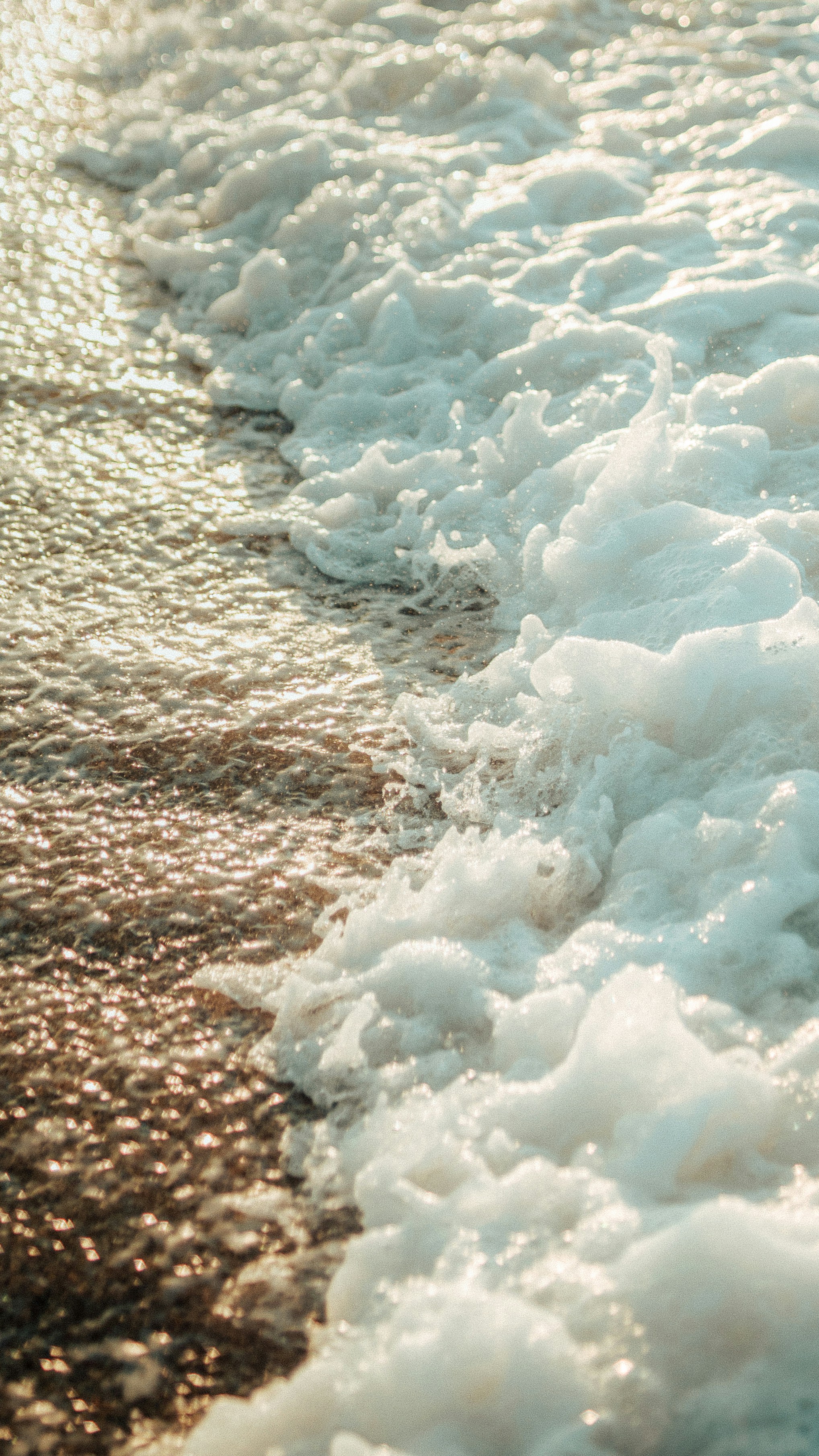 a body of water with ice and snow on the side