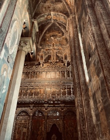 Interior of the church sanctuary with warm golden light illuminating traditional Syriac crosses and motifs.