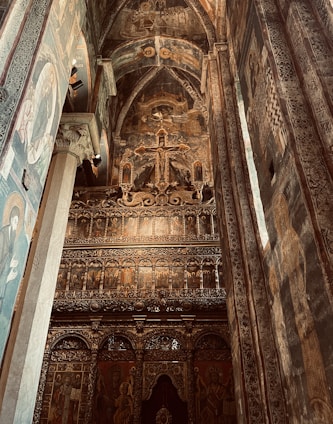 An elegant interior view of a Syriac Orthodox church adorned with traditional crosses and warm liturgical colors.