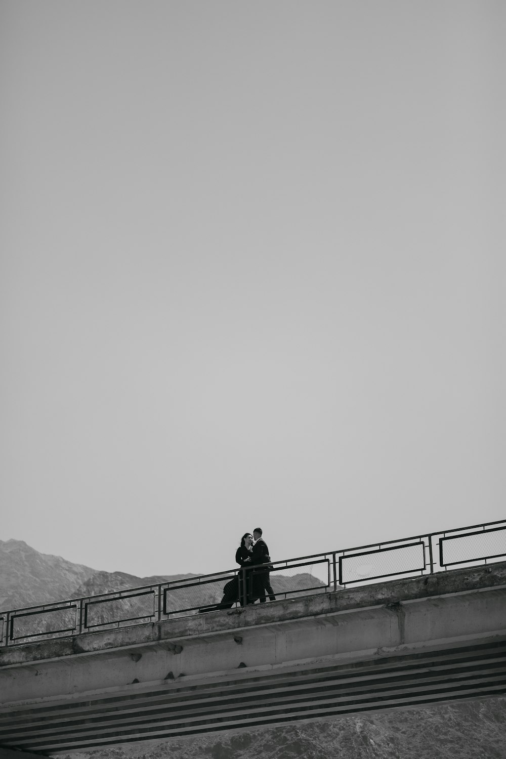 a man and woman standing on a bridge