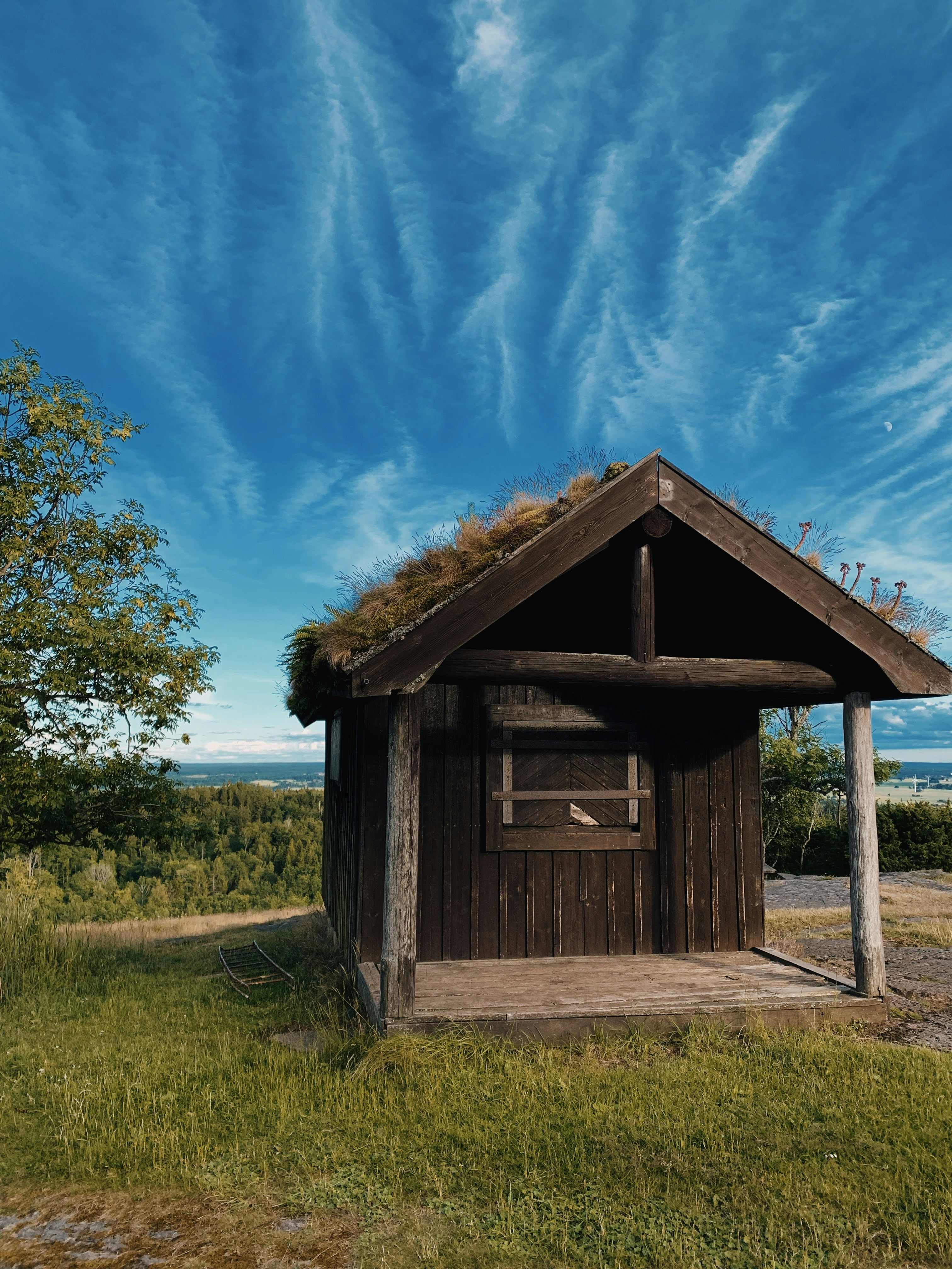 a small wooden building in a grassy area