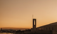 A serene landscape with a church silhouette at sunset.