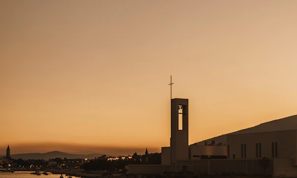 A serene sunset view behind the church building, symbolizing hope and new beginnings.