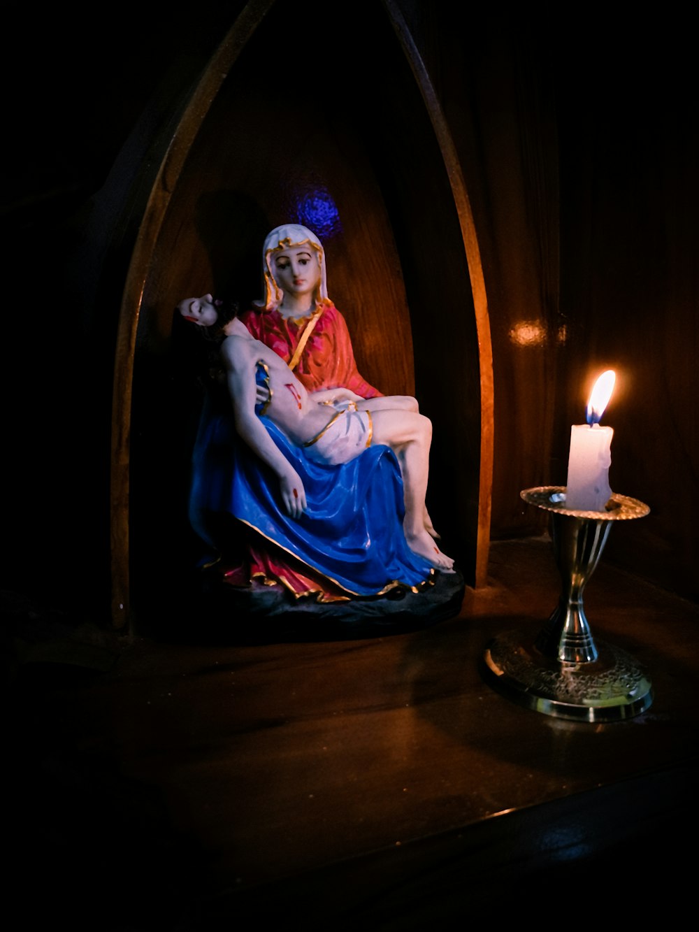 a statue of a person sitting next to a candle