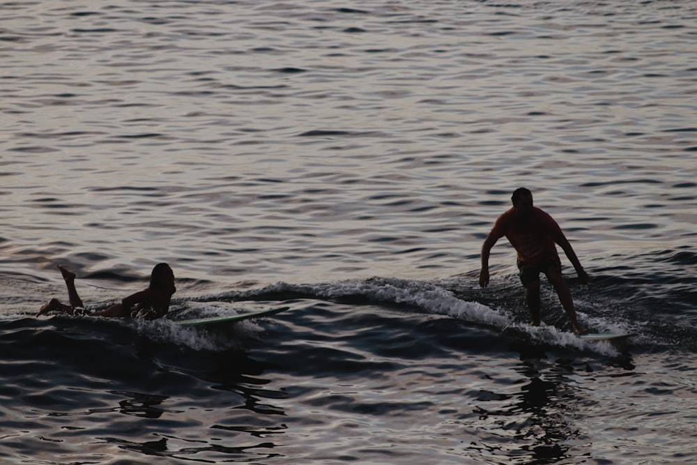 a man and a woman surfing in the sea
