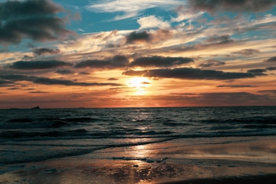 A stunning sunset backdrop with whales visible in the distance.