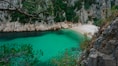 a body of water with a beach and trees around it