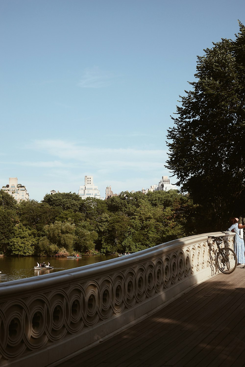 a bridge over a river with trees and buildings in the background