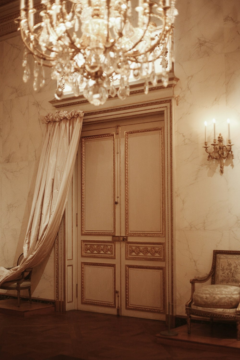 a room with a door and chandelier