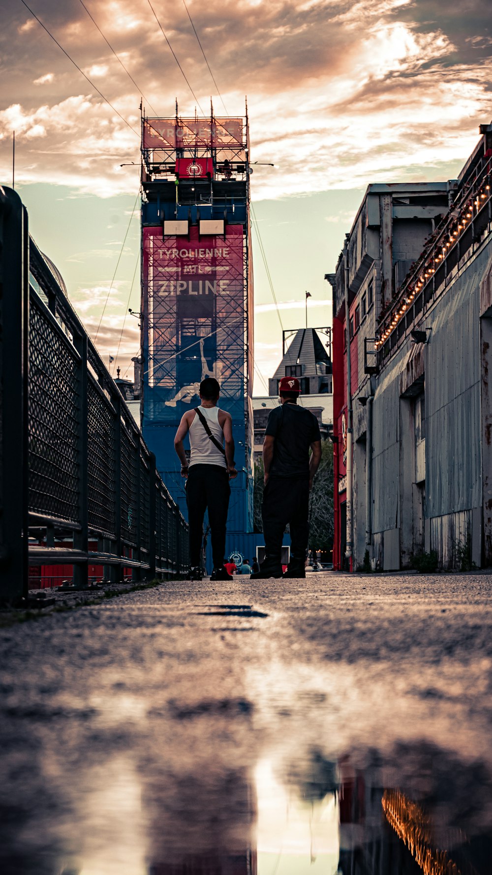 a couple of people standing on a bridge over a body of water