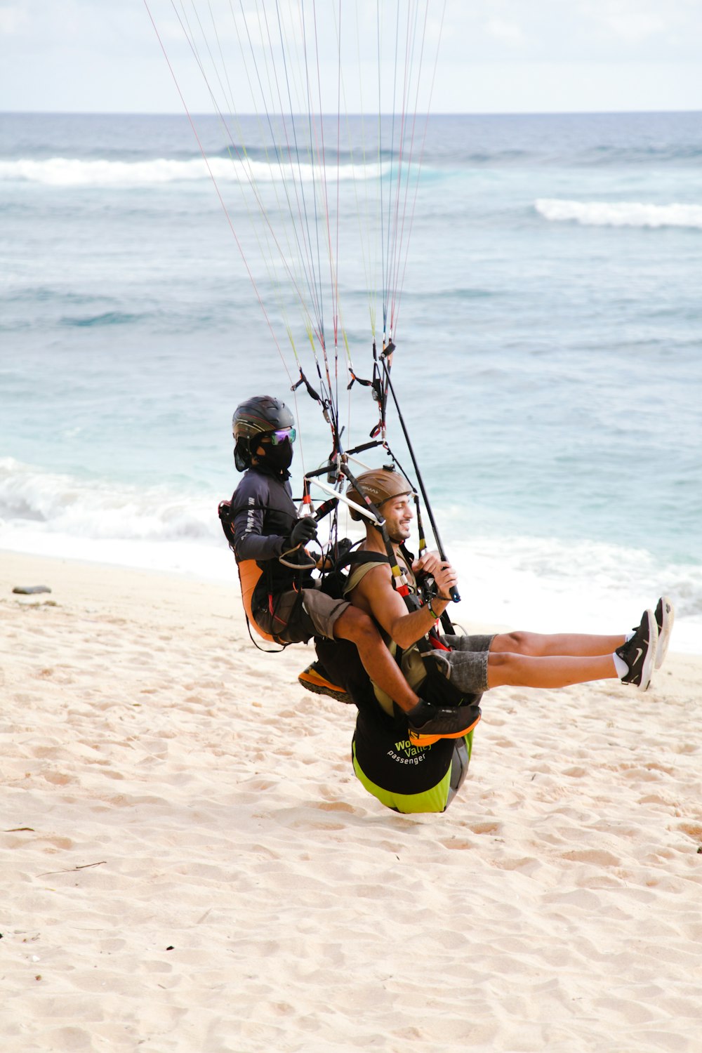 a couple of people parasailing on a beach