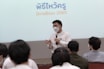 a person speaking into a microphone in front of a group of people