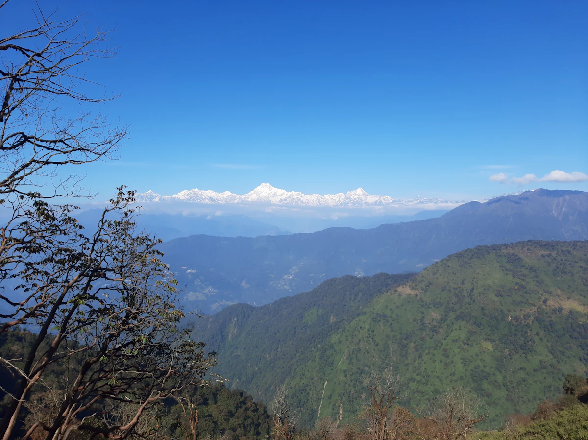 Ridge-top view across misty Darjeeling foothills to the Himalayan snow line