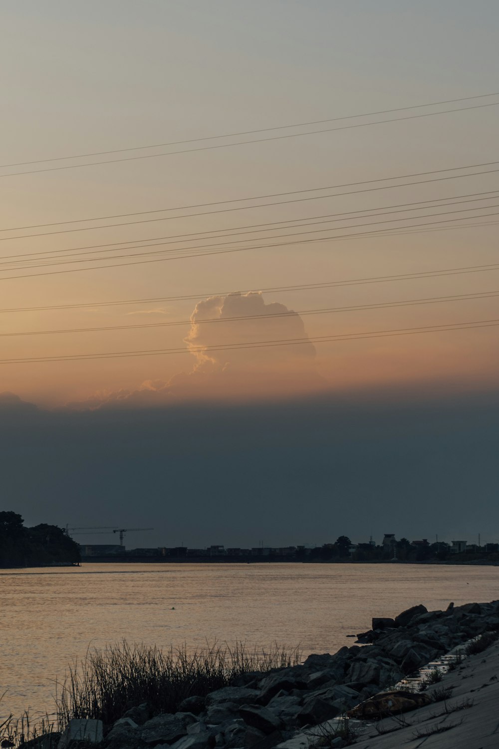 a landscape with a body of water and a cloudy sky