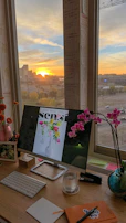 A sunset view from the office window with a laptop open, symbolizing dedication beyond hours.